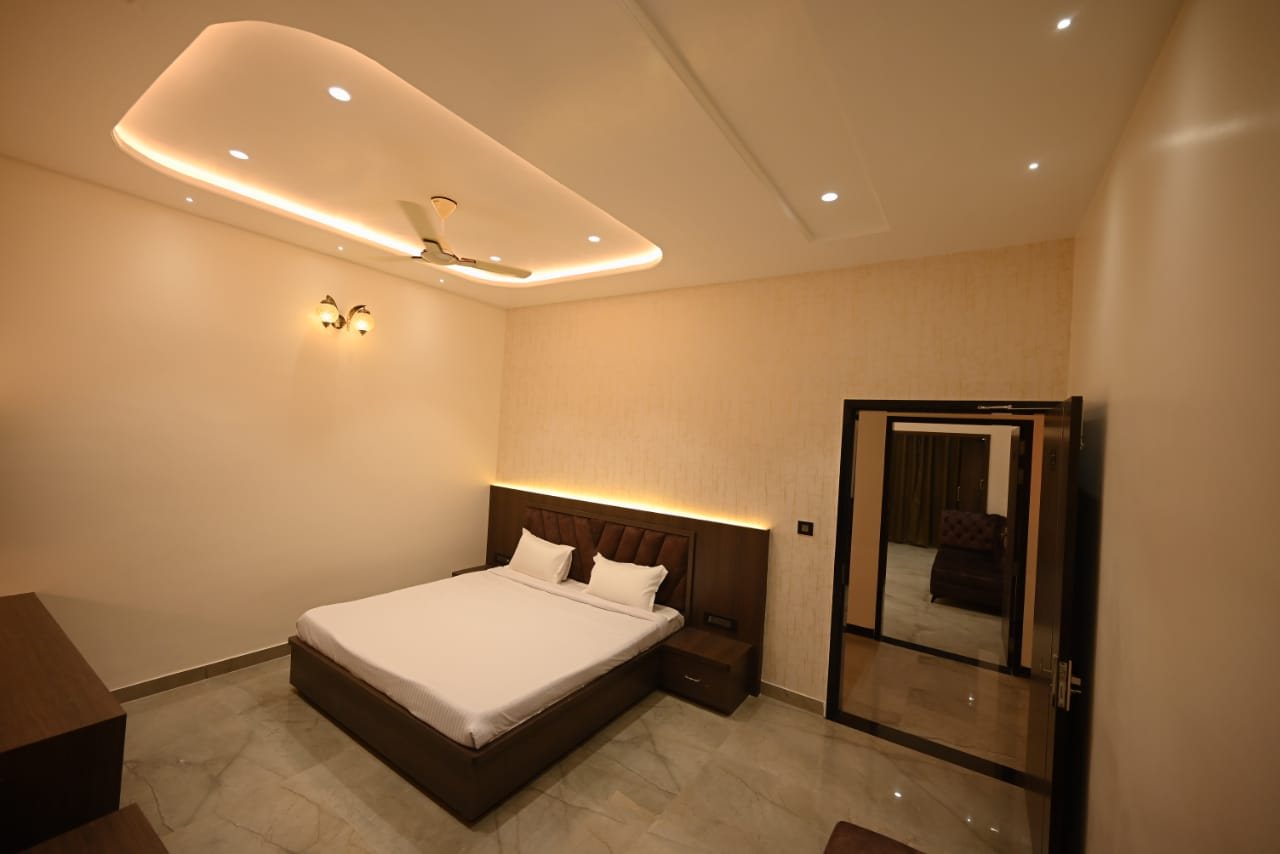 AC guest bedroom at Abhinandan Palace with a double bed, cove lighting and marble flooring
