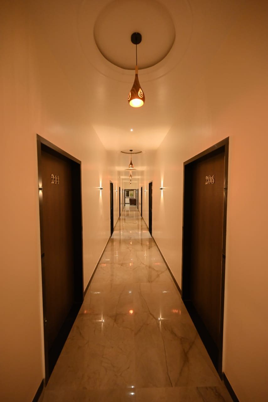 Marble-floored corridor lined with guest room doors at Abhinandan Palace